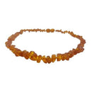 A teething necklace made up of small beads of different shapes. The beads have an orange colour.