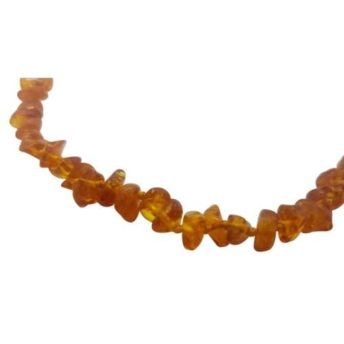 This image shows a close up of the cognac teething necklace made up of small beads of different shapes. The beads have an orange colour.