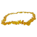 A teething necklace for babies made up of small beads of different shapes. The beads have a golden colour.